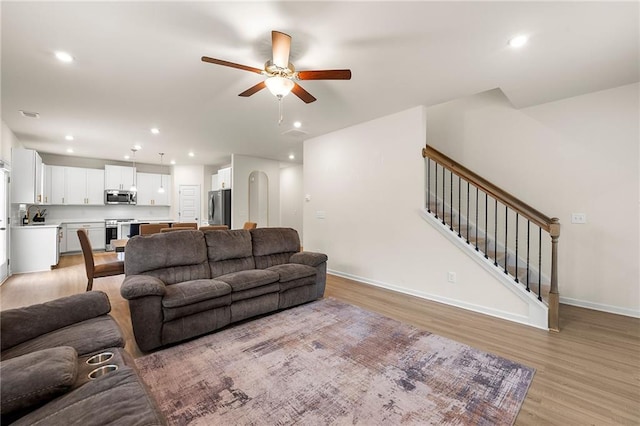 228 Whitneys Way, Dallas, GA 30157 - living room featuring ceiling fan, light wood-type flooring, recessed lighting, baseboards, and stairway