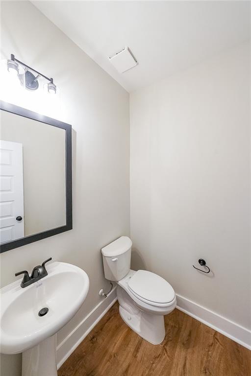 82 Lexie Ct, Rockmart, GA 30153 - half bath with a sink, wood finished floors, toilet, and baseboards