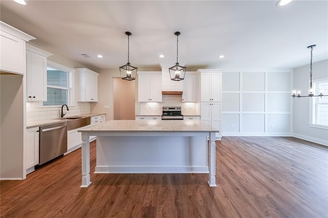 82 Lexie Ct, Rockmart, GA 30153 - kitchen with appliances with stainless steel finishes, backsplash, white cabinetry, wood finished floors, and recessed lighting