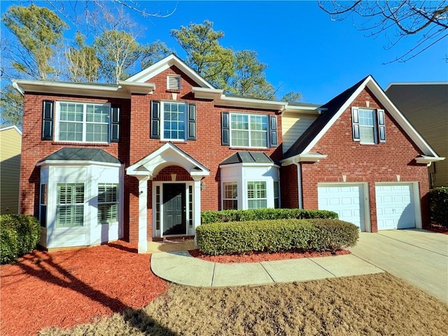 colonial house with a garage, brick siding, and concrete driveway