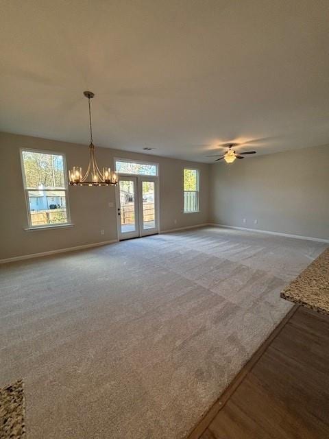 empty room featuring carpet flooring and ceiling fan with notable chandelier