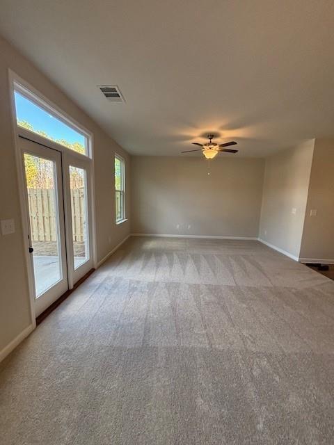 spare room with ceiling fan and light colored carpet