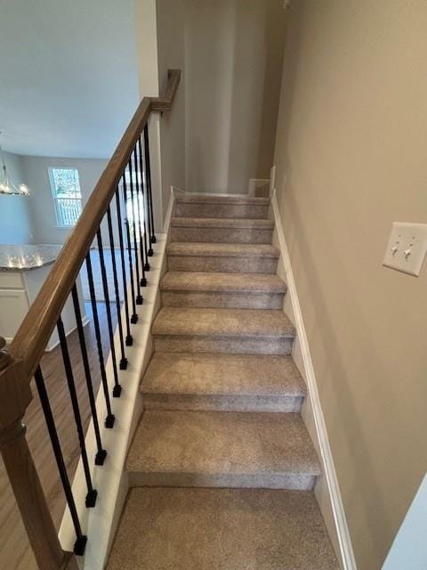 stairs with a chandelier