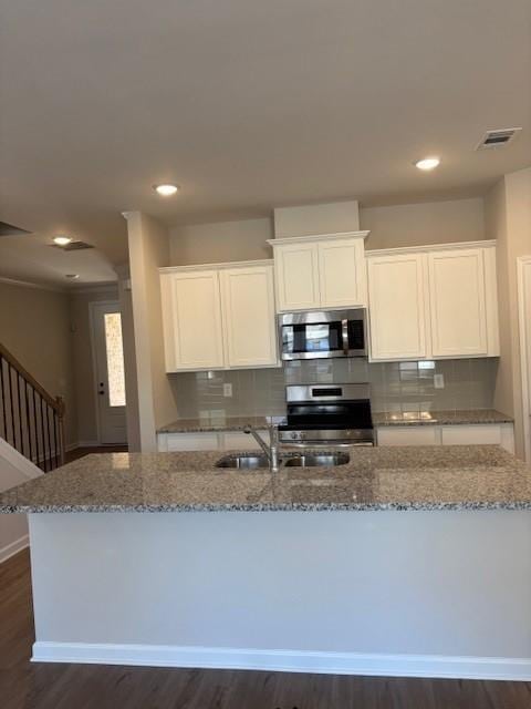 kitchen with white cabinets, range, and light stone countertops