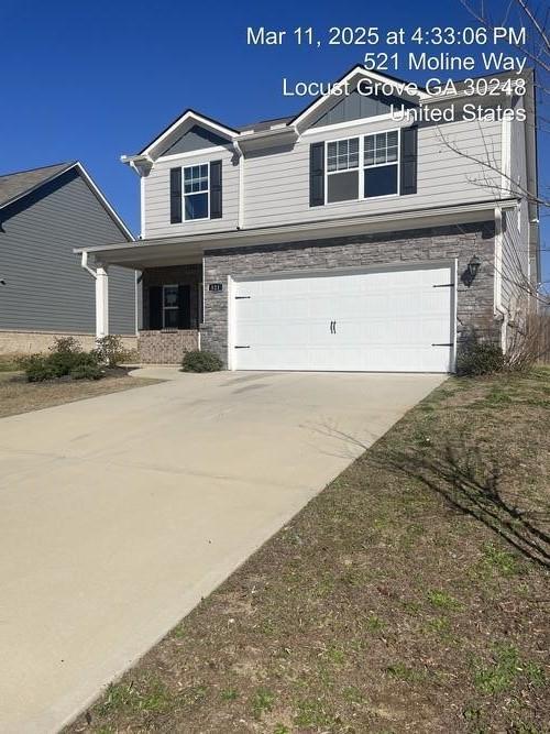 view of front facade with an attached garage, stone siding, and driveway