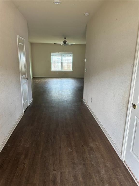 hall featuring baseboards and dark wood finished floors