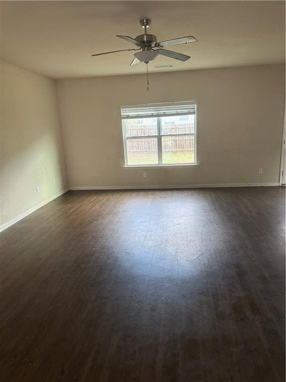 unfurnished room featuring baseboards, dark wood-type flooring, and a ceiling fan