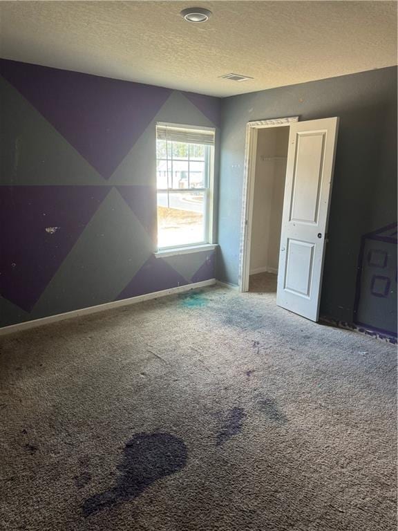 bonus room featuring baseboards, visible vents, carpet floors, and a textured ceiling