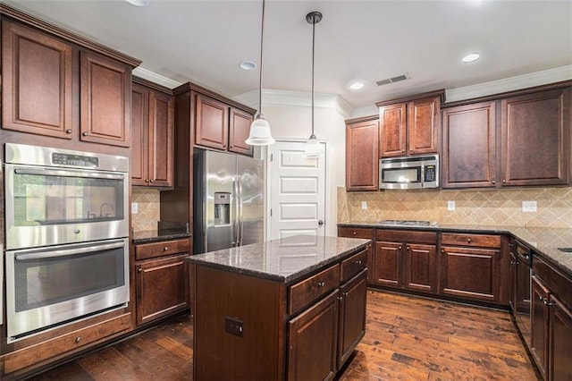 kitchen with tasteful backsplash, dark stone countertops, pendant lighting, a kitchen island, and appliances with stainless steel finishes