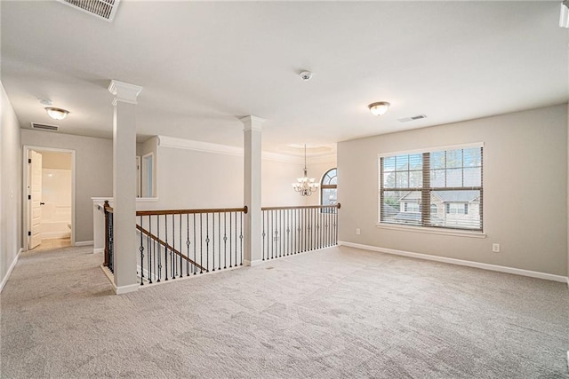 carpeted spare room featuring a chandelier and crown molding