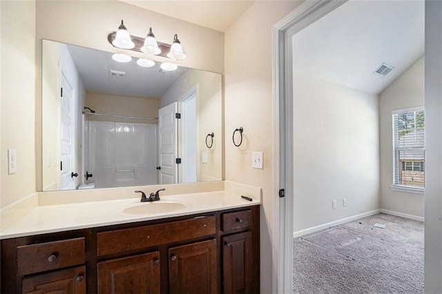 bathroom featuring a shower, vanity, and lofted ceiling