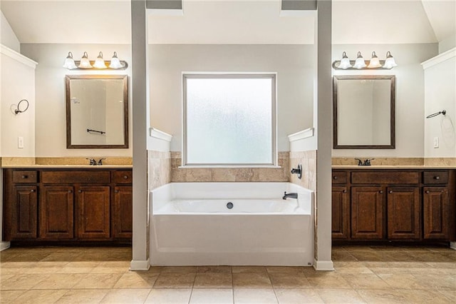 bathroom with a bathing tub, vanity, and tile patterned flooring