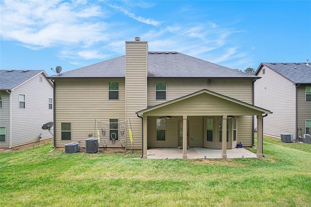 back of property with a patio, central AC, and a lawn