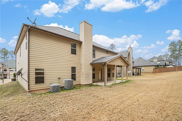 rear view of property with a lawn, ceiling fan, a patio area, and central air condition unit