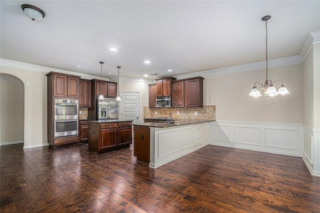 kitchen with crown molding, decorative light fixtures, kitchen peninsula, stainless steel appliances, and a chandelier