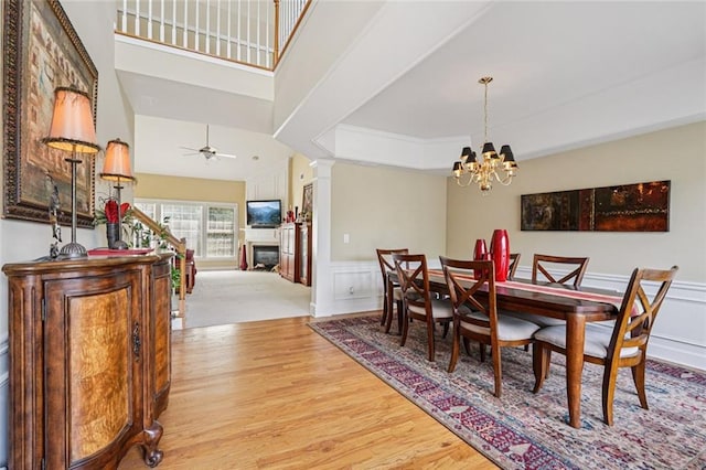 25 Hampreston Ct, Johns Creek, GA 30022 - dining room featuring light wood-style flooring, ornate columns, a chandelier, a decorative wall, and crown molding