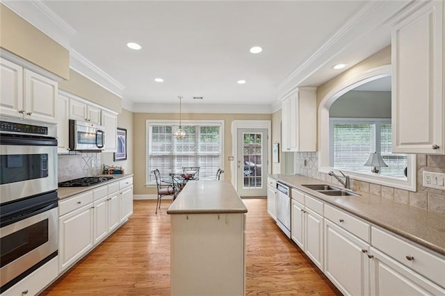 25 Hampreston Ct, Johns Creek, GA 30022 - kitchen featuring appliances with stainless steel finishes, a kitchen island, light wood-style flooring, tasteful backsplash, and white cabinetry