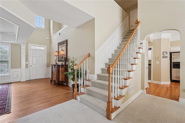 25 Hampreston Ct, Johns Creek, GA 30022 - foyer entrance with wood finished floors, a high ceiling, arched walkways, stairway, and wainscoting