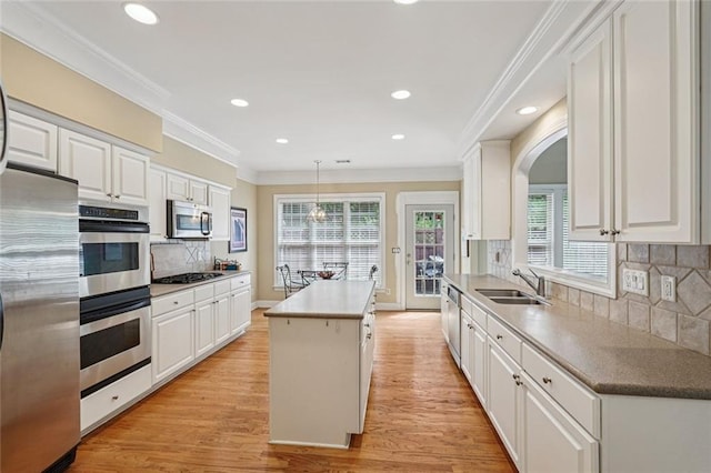 25 Hampreston Ct, Johns Creek, GA 30022 - kitchen with stainless steel appliances, a kitchen island, white cabinets, crown molding, and arched walkways