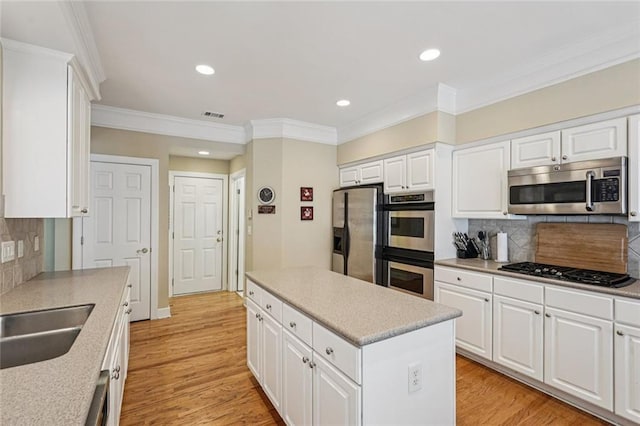 25 Hampreston Ct, Johns Creek, GA 30022 - kitchen with stainless steel appliances, ornamental molding, a kitchen island, decorative backsplash, and white cabinets