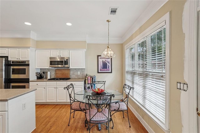 25 Hampreston Ct, Johns Creek, GA 30022 - kitchen featuring appliances with stainless steel finishes, light countertops, light wood-type flooring, tasteful backsplash, and crown molding