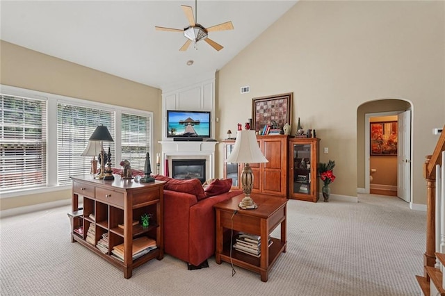 25 Hampreston Ct, Johns Creek, GA 30022 - living area featuring light colored carpet, a ceiling fan, arched walkways, a glass covered fireplace, and high vaulted ceiling