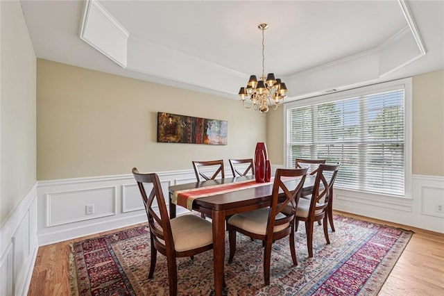 25 Hampreston Ct, Johns Creek, GA 30022 - dining space featuring a raised ceiling, wood finished floors, a chandelier, a wainscoted wall, and a decorative wall
