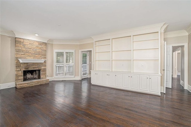 unfurnished living room featuring crown molding, dark hardwood / wood-style flooring, built in features, and a stone fireplace