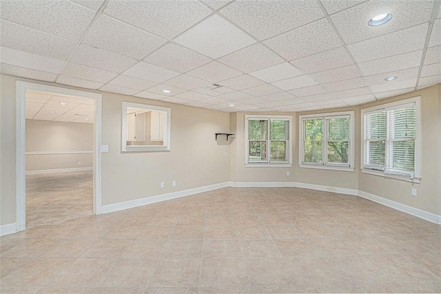 tiled empty room with a paneled ceiling