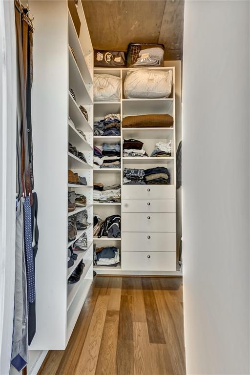 walk in closet with wood finished floors