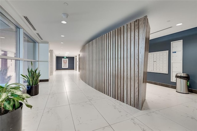 hallway featuring visible vents, baseboards, marble finish floor, mail area, and recessed lighting