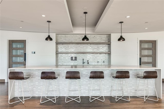 bar with dark wood-style floors, wet bar, hanging light fixtures, and recessed lighting