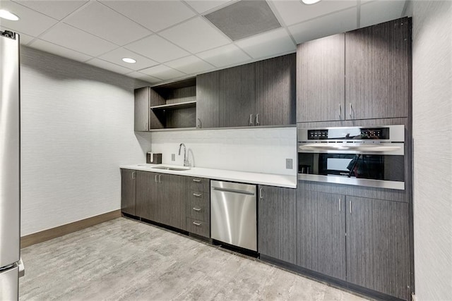 kitchen with stainless steel appliances, a paneled ceiling, light wood-style floors, open shelves, and a sink