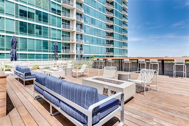 wooden deck featuring an outdoor living space with a fire pit