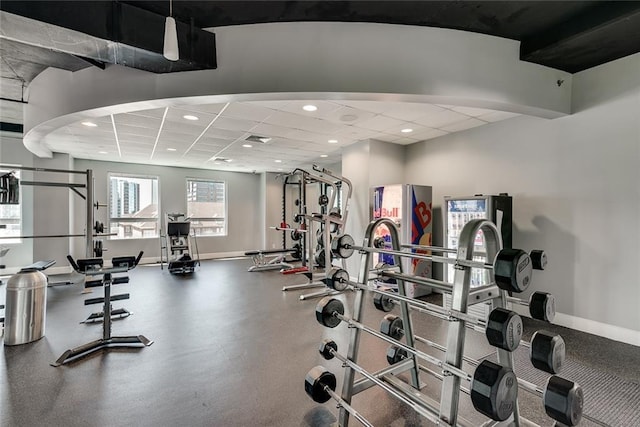 exercise room with a paneled ceiling, visible vents, baseboards, and recessed lighting