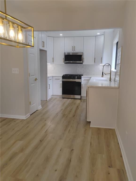 2645 Trotters Walk Trl, Snellville, GA 30078 - kitchen with electric stove, stainless steel microwave, a sink, backsplash, and white cabinets