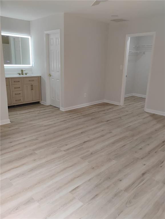 2645 Trotters Walk Trl, Snellville, GA 30078 - unfurnished bedroom with light wood-style floors, baseboards, and a walk in closet