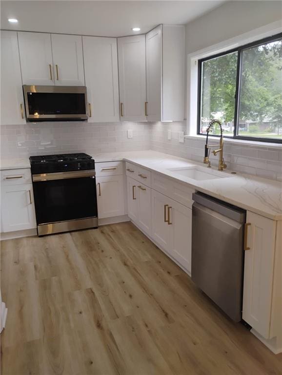 2645 Trotters Walk Trl, Snellville, GA 30078 - kitchen featuring appliances with stainless steel finishes, a sink, decorative backsplash, plenty of natural light, and recessed lighting