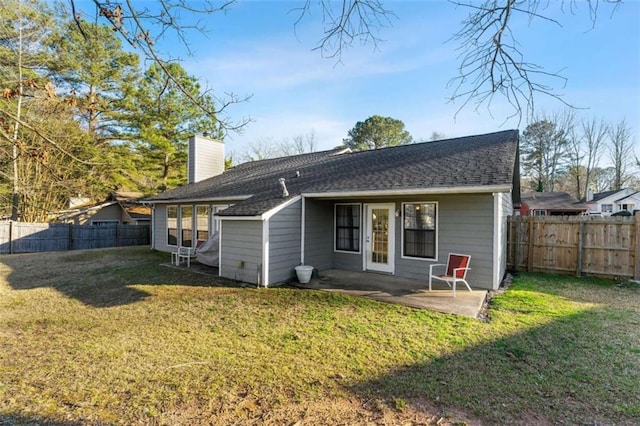 rear view of house with a lawn, a fenced backyard, and a chimney