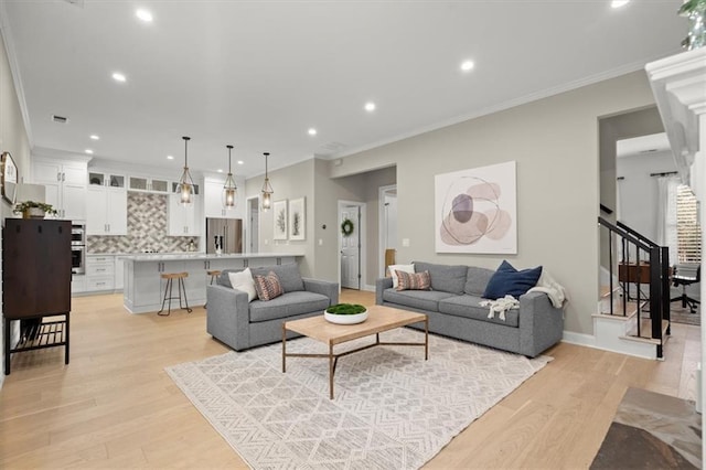 living room featuring light hardwood / wood-style floors and crown molding