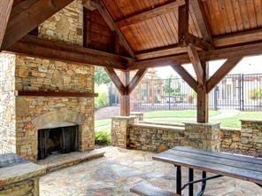 view of patio featuring a gazebo and an outdoor stone fireplace