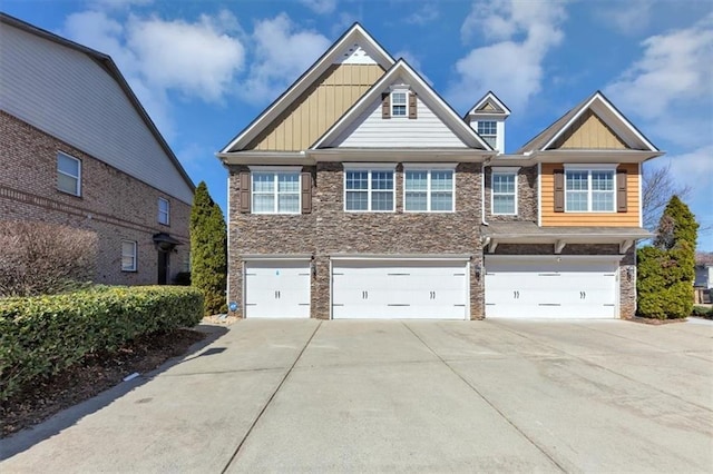 craftsman-style house featuring concrete driveway, an attached garage, board and batten siding, and stone siding