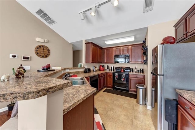 kitchen with black appliances, a peninsula, visible vents, and a sink