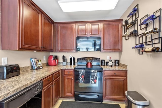 kitchen featuring light stone countertops, reddish brown cabinets, and black appliances