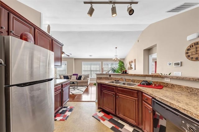 kitchen with visible vents, lofted ceiling, freestanding refrigerator, a sink, and black dishwasher