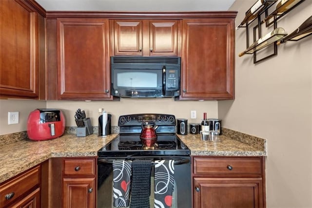 kitchen featuring black appliances and light stone countertops