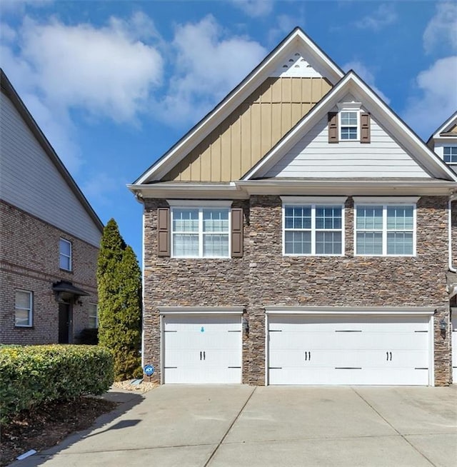 view of front of home featuring stone siding, board and batten siding, concrete driveway, and a garage