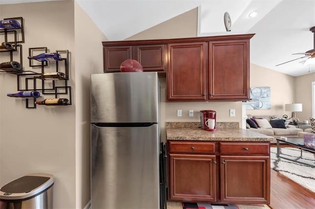 kitchen with a ceiling fan, wood finished floors, open floor plan, freestanding refrigerator, and lofted ceiling