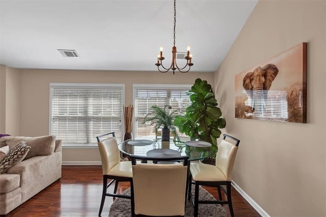 dining room featuring visible vents, a notable chandelier, a healthy amount of sunlight, and wood finished floors