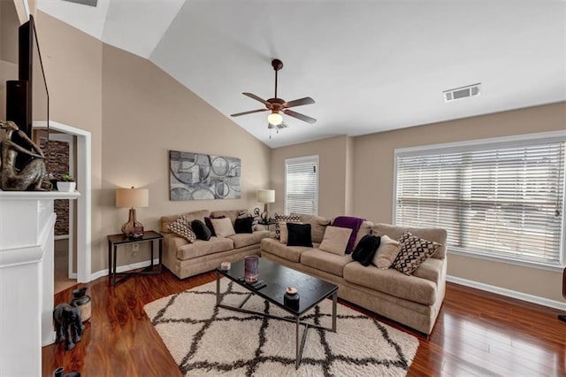 living area with a ceiling fan, wood finished floors, visible vents, baseboards, and vaulted ceiling